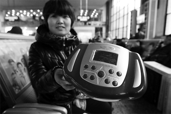 火車(chē)站候車(chē)室，李女士向記者展示她準(zhǔn)備孝敬父母的按摩儀