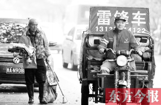 鄭州市商城路，一名環(huán)衛(wèi)工懷抱著剛剛收到的毯子，目送“雷鋒哥”孫德坤離開(kāi)