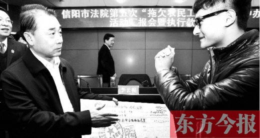 張立勇將依法執(zhí)行回來的農(nóng)民工工資發(fā)放給案件當事人游昌華，游昌華施以中國傳統(tǒng)作揖禮答謝