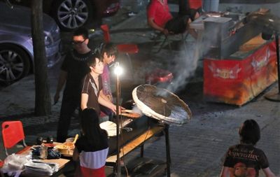 7月4日，青年路國(guó)美第一城小區(qū)附近的夜市臨街露天燒烤攤。