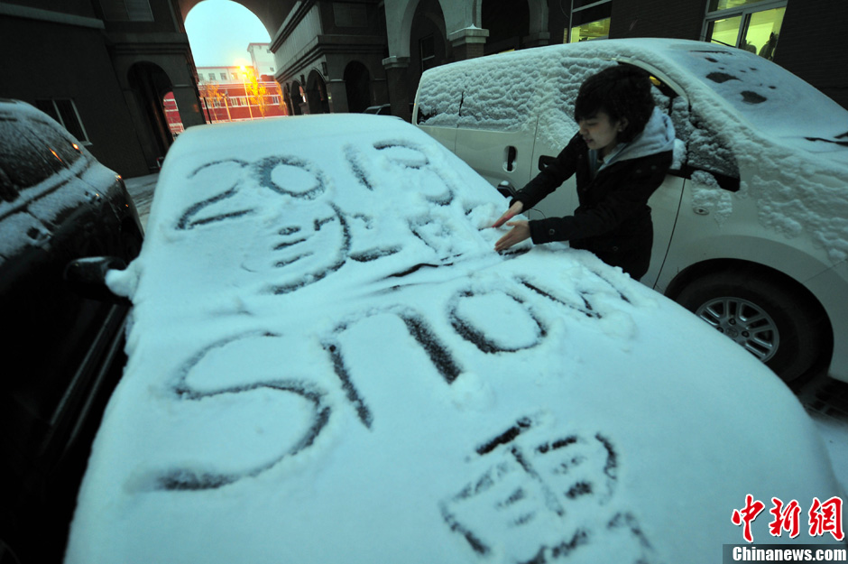 11月18日，行人在車輛的積雪上涂鴉。