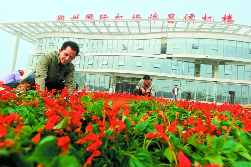 9月23日，工人們正在鄭州國際機(jī)場許昌候機(jī)樓前擺放鮮花。