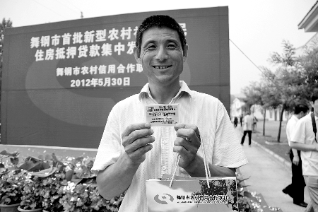 領(lǐng)到貸款，農(nóng)民開心地笑了。