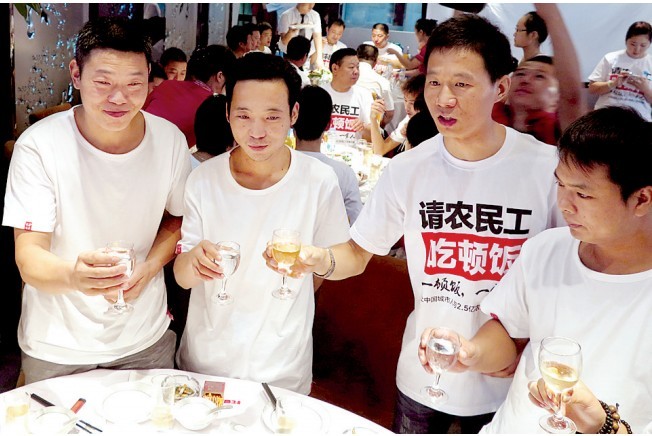 活動發(fā)起人張楠（右二）給農民工敬酒。