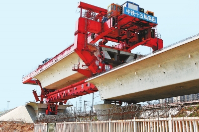 建設(shè)者們操縱巨型起重機(jī)在吊放橋墩。記者鄧放攝