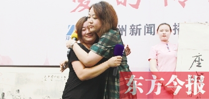 最終競拍成功的盧女士與李剛妻子(左一)相擁在一起 最終競拍成功的盧女士與李剛妻子(左一)相擁在一起