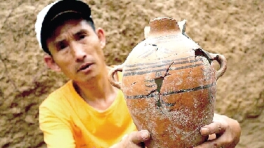 　　考古工作人員展示出土的仰韶文化時(shí)期代表性彩陶。