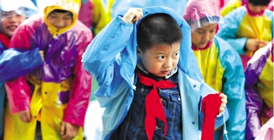 昨日下午,農(nóng)科路上一小學放學時,孩子們大部分都穿著雨披。