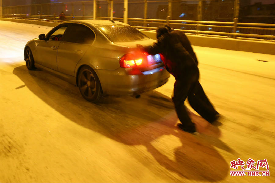 兩位“推車人”奮力的推著小車上橋。