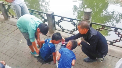 男孩被救出后，圍觀群眾幫他控水換衣服。