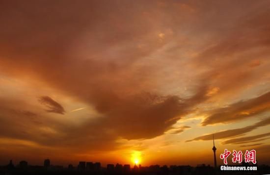 12月8日下午，強(qiáng)烈的西北風(fēng)光臨北京，吹散了籠罩全城上空的霧霾，冬日罕見(jiàn)的艷麗晚霞映紅了半邊天。