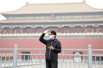 11月1日，北京大部分地區(qū)重度污染，一名游客戴著口罩在午門前揮手跟朋友打招呼。 實(shí)習(xí)生 王飛 攝