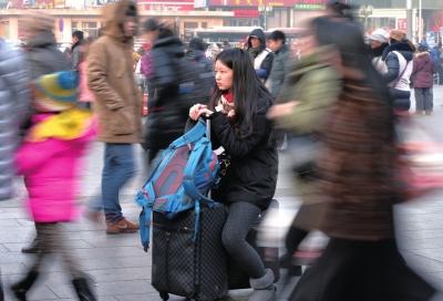 春運(yùn)首日，北京站客流量明顯增多，一名女孩在人流中等待進(jìn)站。