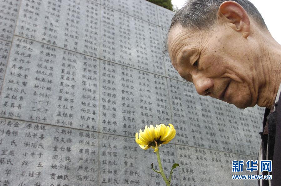 2006年4月5日，74歲的南京大屠殺幸存者佘子清手捧鮮花，祭奠被日軍殺害的母親。