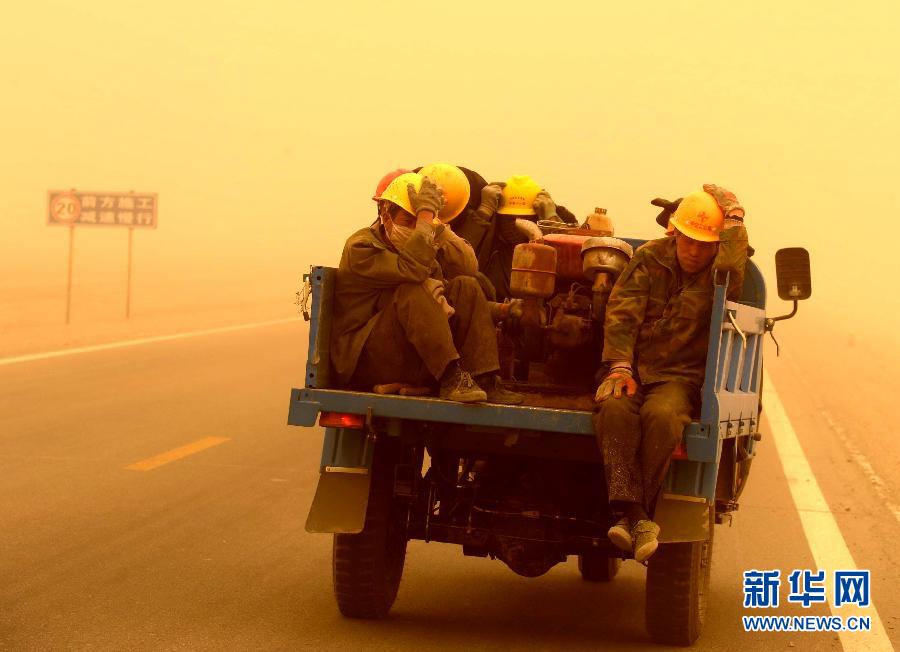 4月23日，一輛拉載公路施工人員的三輪車在沙塵暴中行駛在酒泉市瓜州縣城郊的公路上。
