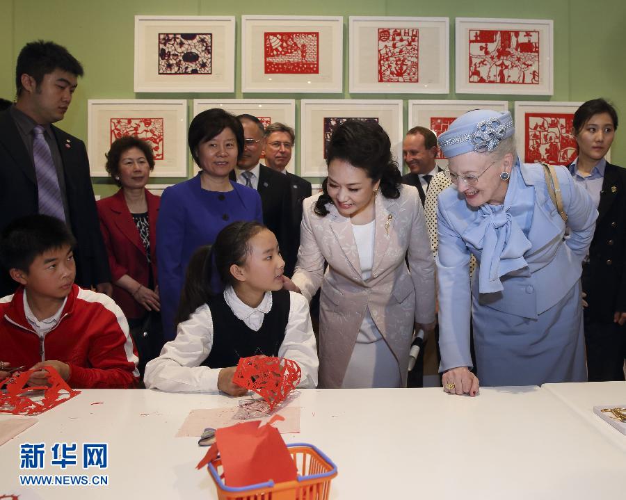 這是彭麗媛和瑪格麗特二世與根據(jù)安徒生童話中人物和情節(jié)制作剪紙的孩子交談。