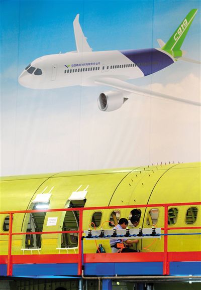 昨日，中國商飛總裝制造中心技術人員對接C919首架機的機體。新華社記者 丁汀 攝