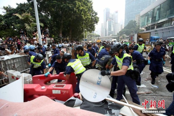 10月14日，警方清除金鐘道障礙物。大批警員在金鐘道現(xiàn)場(chǎng)清拆障礙物。部分警員戴上頭盔將障礙物移走。