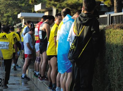 2013年10月20日，北京馬拉松比賽，由于廁位有限，一些選手在綠化帶“就地解決”。圖/IC