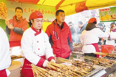 賣羊肉串?dāng)偽焕习遐w山（穿紅衣者）。新京報(bào)記者