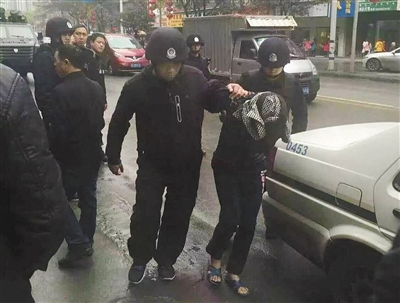 達(dá)州市警方押解剛被抓獲的犯罪嫌疑人褚思練（裹頭巾者）。 本組圖片/新華社