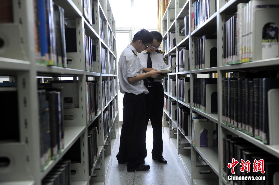 5月8日，武漢輕工大學(xué)保安吳濤與江力在圖書館交流學(xué)習(xí)。中新社發(fā) 張暢 攝