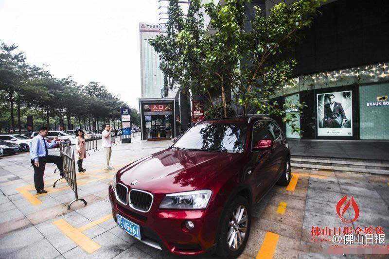 一輛停在停車(chē)位上的寶馬轎車(chē)，被墜落的樹(shù)枝砸中，樹(shù)枝徑直插入車(chē)內(nèi)，現(xiàn)場(chǎng)引發(fā)不少市民圍觀拍照。