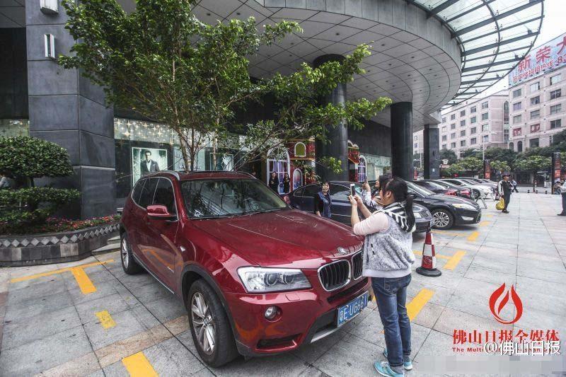 一輛停在停車(chē)位上的寶馬轎車(chē)，被墜落的樹(shù)枝砸中，樹(shù)枝徑直插入車(chē)內(nèi)，現(xiàn)場(chǎng)引發(fā)不少市民圍觀拍照。