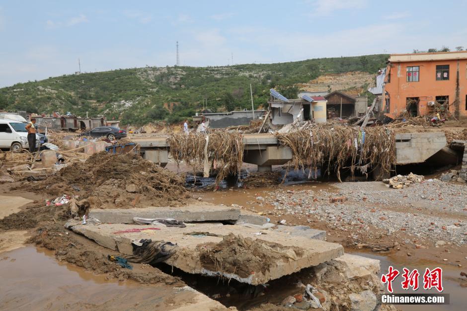 圖為洪水過后，坍塌的橋梁上遺落大量雜草。