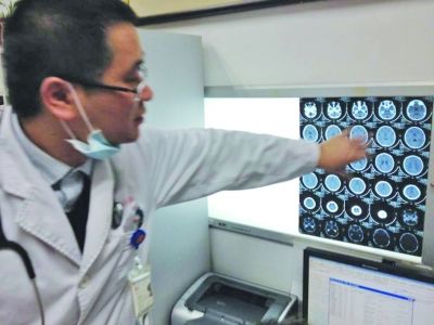 醫(yī)生在查看男孩的腦部CT片。薛馬義 攝