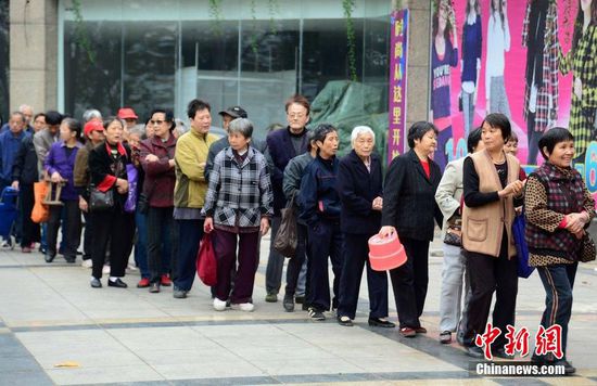 圖為10月28日，在江西九江市一家羊絨皮草服裝服飾博覽會(huì)現(xiàn)場(chǎng)，老人們正在頂著寒風(fēng)排隊(duì)等待領(lǐng)取10元代金劵。