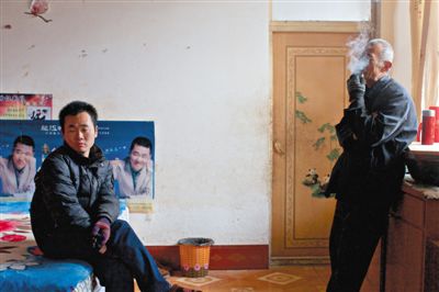 父親抽煙，兒子不語(yǔ)。逃跑的越南新娘，給袁迎賓父子帶來(lái)的是失落。新京報(bào)記者 周崗峰 攝