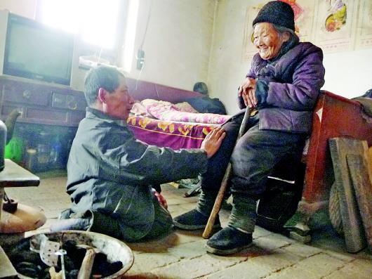 52歲的劉蘭山每天靠爬行照顧90歲的老母親。孫國祥 攝