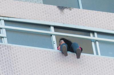 28樓的窗臺上坐著一名女子，其兩條腿耷拉在室外，不停地擺動。