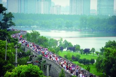 　　昨天,數(shù)萬南京市民參加“環(huán)城七十里”徒步走,圖為解放門城墻上密集的人群。 本版攝影 實習(xí)生 王甜