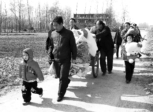 姐（左一）弟（右一護(hù)士懷中男嬰）返鄉(xiāng)，愛心捐贈(zèng)滿滿一架子車。