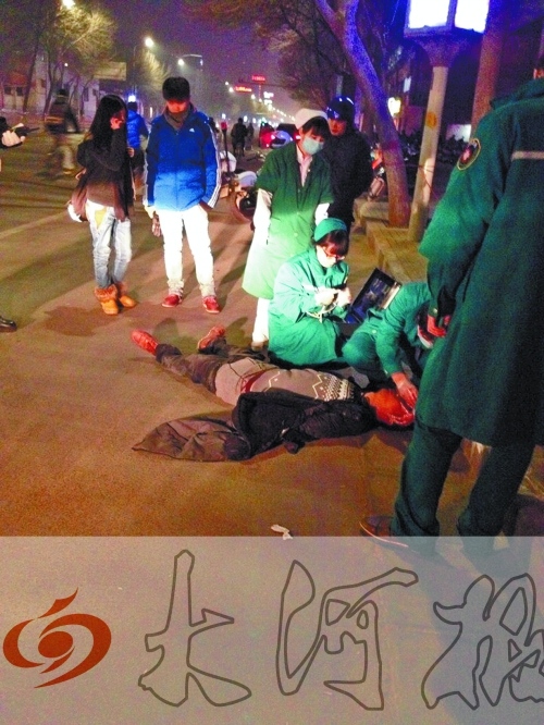 醉漢躺在地上，醫(yī)護(hù)人員對其進(jìn)行檢查。
